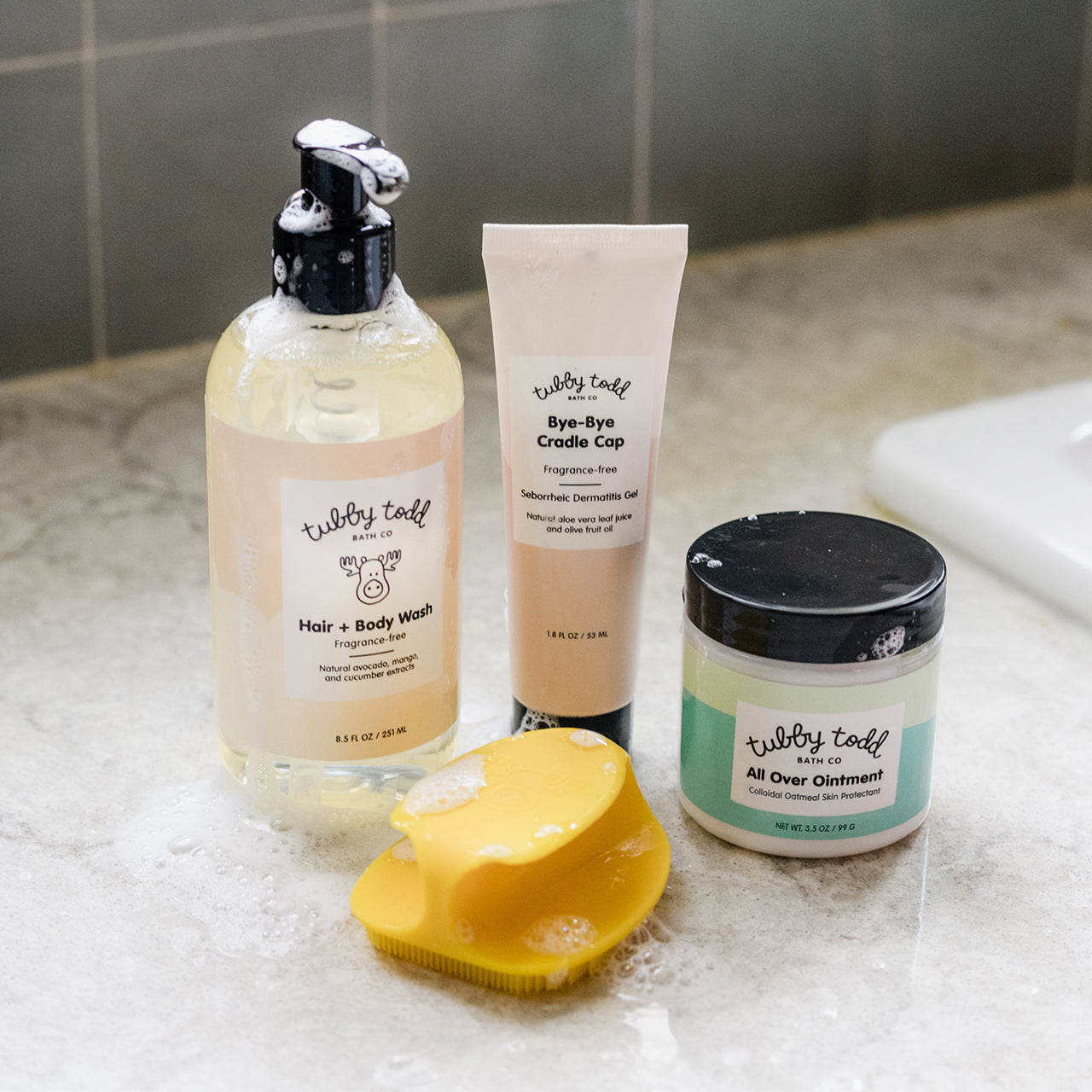 Bye-Bye Cradle Cap Bundle next to sink with suds on bottles